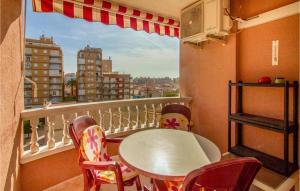 einen Balkon mit einem Tisch und Stühlen sowie einem Fenster in der Unterkunft Lovely Apartment In Santa Pola With Kitchenette in Santa Pola