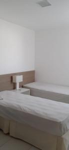 1 dormitorio con 1 cama grande y 1 mesa en Residencial Iloa, en Barra de São Miguel