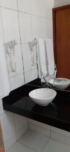 baño con encimera negra con fregadero en Residencial Iloa, en Barra de São Miguel