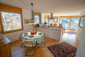 a kitchen and dining room with a table and chairs at Chasa Weekend in Scuol