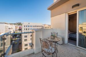 einen Balkon mit einem Tisch und Stühlen sowie Stadtblick in der Unterkunft Diros Hotel in Athen