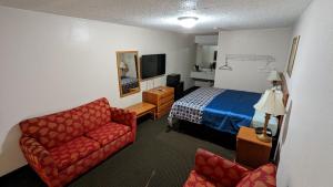 a hotel room with a bed and a couch at Eufaula Inn in Eufaula