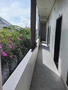 un couloir d'un bâtiment aux fleurs roses dans l'établissement Yanti Guest House, à Canggu