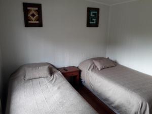 two beds sitting next to each other in a room at Hospedaje Irma Backpackers in Pucón