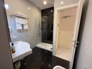 ein Bad mit einer Dusche, einem Waschbecken und einem WC in der Unterkunft Hotel Smart Cruise in Civitavecchia