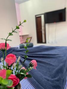 a bedroom with two beds with blue sheets and red flowers at Pousada Center in Barreirinhas