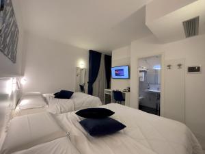 Habitación de hotel con 2 camas y lavamanos en Hotel Smart Cruise, en Civitavecchia