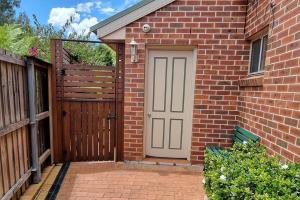 una casa de ladrillo con una puerta y una valla en Guest Studio in Campbelltown, 