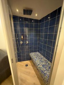 a blue tiled bathroom with a bench in the shower at Hotel Smart Cruise in Civitavecchia
