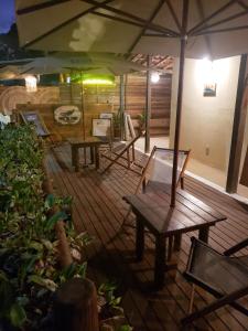 a wooden deck with benches and umbrellas at CASA MAR DE FORA in Fernando de Noronha