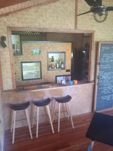 a bar with three stools in front of a counter at At Home in Puerto Princesa City