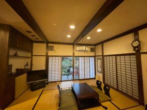 仙石原にあるSecret Garden Resort&Onsen秘密の花園箱根温泉別荘のテーブル、椅子、時計が備わる客室です。