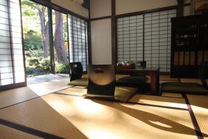 Cette chambre comprend une table, des chaises et des fenêtres. dans l'établissement Secret Garden Resort&Onsen秘密の花園箱根温泉別荘, à Sengokuhara