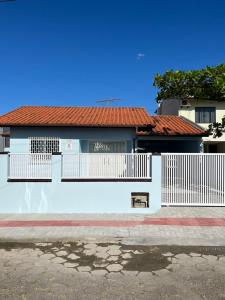 una casa blanca con una valla blanca delante de ella en Casa da Penha/SC, en Penha