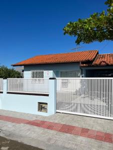una cerca blanca frente a una casa en Casa da Penha/SC, en Penha