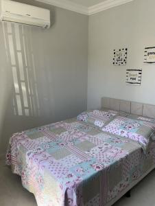 Una cama con edredón en un dormitorio en Casa da Penha/SC, en Penha
