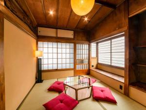 a meditation room with red pillows and a glass table at NIPPONIA Chichibu Monzenmachi in Chichibu