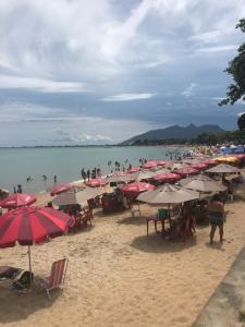 een strand met veel parasols en mensen in het water bij Flat da Praia Rio das Ostras in Rio das Ostras