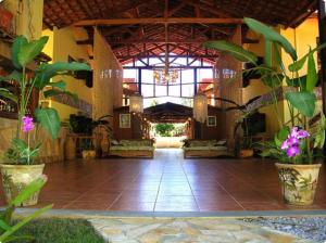 a lobby of a building with a large window and plants at Canto de Itamambuca in Ubatuba