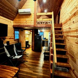 a room with wooden walls and stairs in a cabin at The Windstorm Cabin - Pet-friendly & a 2-person Jacuzzi hot tub! in Marshall