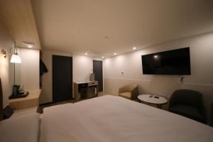 Uiwangにある25 Hotelのベッド1台、薄型テレビが備わるホテルルームです。