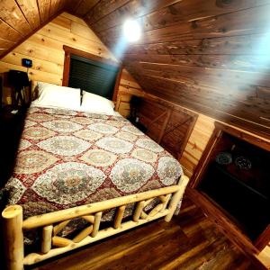 a bedroom with a bed in a wooden cabin at The Windstorm Cabin - Pet-friendly & a 2-person Jacuzzi hot tub! in Marshall