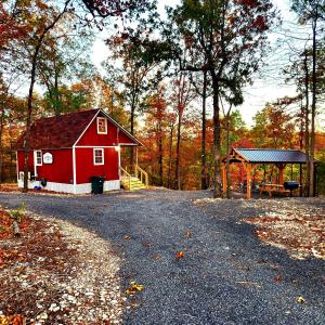 a red barn and a gazebo in the woods at The Windstorm Cabin - Pet-friendly & a 2-person Jacuzzi hot tub! in Marshall