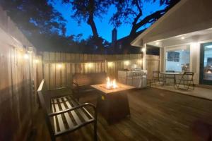 a deck with a bench and a table with a fire at NEW! ATX Home with 3 Patios, 3 TVs, & Fire Pit in Austin