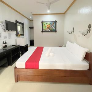 a bedroom with a bed with a red and white blanket at RedDoorz New Casamila Hotel Palawan in Puerto Princesa City