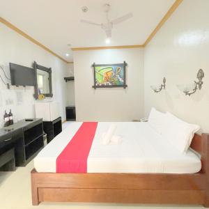 a bedroom with a bed and a desk and a television at RedDoorz New Casamila Hotel Palawan in Puerto Princesa City
