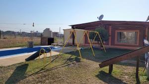 a playground in front of a house with a slide at Cabaña Solares in La Silleta