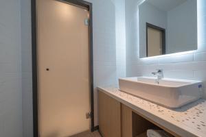 ein Bad mit einem Waschbecken und einem Spiegel in der Unterkunft Brown Dot Siheung Geobuksum in Siheung
