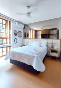 - une chambre avec un grand lit et un couvre-lit blanc dans l'établissement Incrível Casa com Hidro-bikes-centro de Gramado 3Q, à Gramado