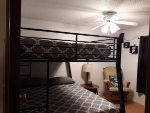 a bedroom with a bunk bed with a ceiling fan at Overlook Lakehouse on Chippewa Lake Close to Haymarsh State Game Area and Ferris State College in Barryton