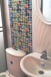 a bathroom with a toilet and a sink and a mosaic shower curtain at MALALA3 depa amoblado in Sincelejo