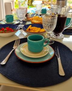 Una mesa con un plato de comida y una taza de café. en Vila Leão do Norte, en Japaratinga