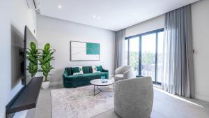 a living room with a green couch and a table at Mabaat-Superior 2BR-Al Aqiq 399 in Riyadh