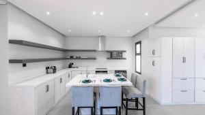 a kitchen with white cabinets and a island with stools at Mabaat - Al Aqiq - 399 in Riyadh