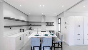a kitchen with white cabinets and a island with stools at Mabaat-Superior 2BR-Al Aqiq 399 in Riyadh