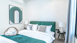 a bedroom with a bed with a green headboard at Mabaat-Superior 2BR-Al Aqiq 399 in Riyadh