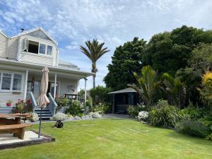 a house with a lawn with an umbrella at Nikau Lodge in Kaikoura