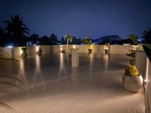 a lit up courtyard at night with flowers and lights at La Paradise Luxury - TIE Hotels in Pondicherry