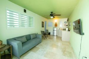 a living room with a blue couch and a kitchen at La Esmeralda PR in San Juan