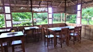 um restaurante com mesas e cadeiras e uma grande janela em The Lazy Tiki em Buenavista