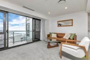 a living room with a couch and a glass table at QV Stays Upscale Modern Getaway in Auckland