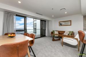 a living room with a table and a couch at QV Stays Upscale Modern Getaway in Auckland