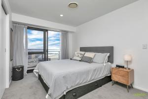 a bedroom with a large bed and a large window at QV Stays Upscale Modern Getaway in Auckland +21 photos
