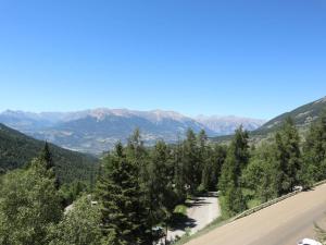 droga z drzewami i górami w tle w obiekcie Studio 4 pers en cœur de station, balcon vue montagne - FR-1-322-500 w mieście Les Orres