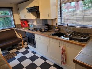 a small kitchen with a sink and a stove at Shergold Rooms in Swindon