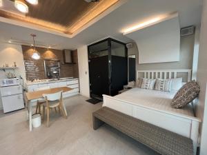 a bedroom with a bed and a table and a kitchen at Somewhales Pension in Namhae